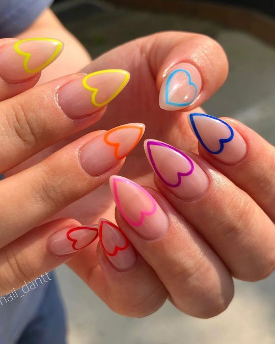 Almond-shaped nails with clear base and colorful heart outlines