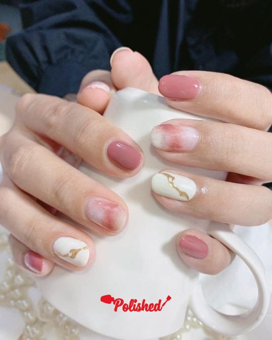 shrot nails alternate between pastel pink and white golden marble effect
