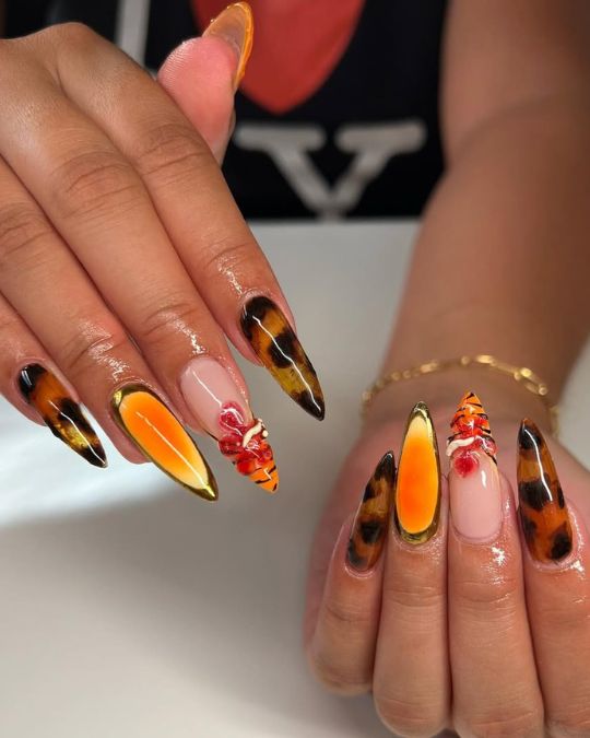 fiery oranges and sleek amber tortoiseshell pattern on long almond nails