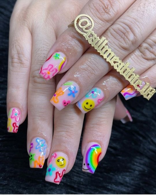 short square nails with pop art smiley faces, rainbows, and funky flowers
