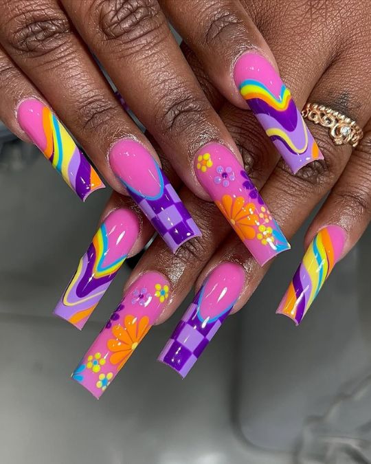 a mix of purple, pink and yellow with creative hand drawing patterns on long square nails