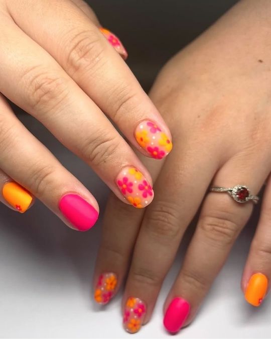 short round nails with hot pink and orange floral designs