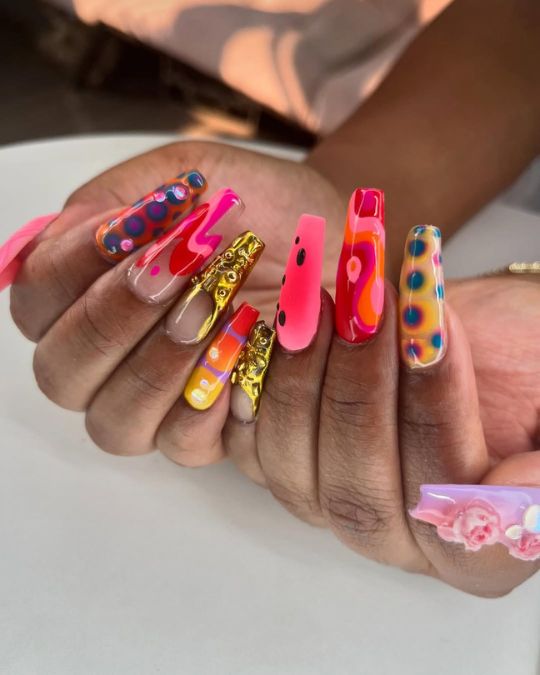 long coffin nails with a mix of hot pinks, electric blues, and pops of gold