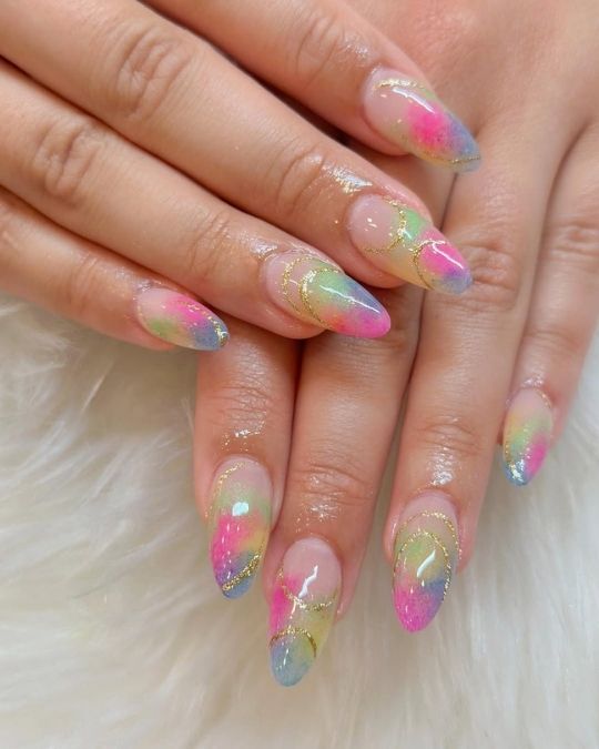 Pastel watercolors blend with golden lines almond nails