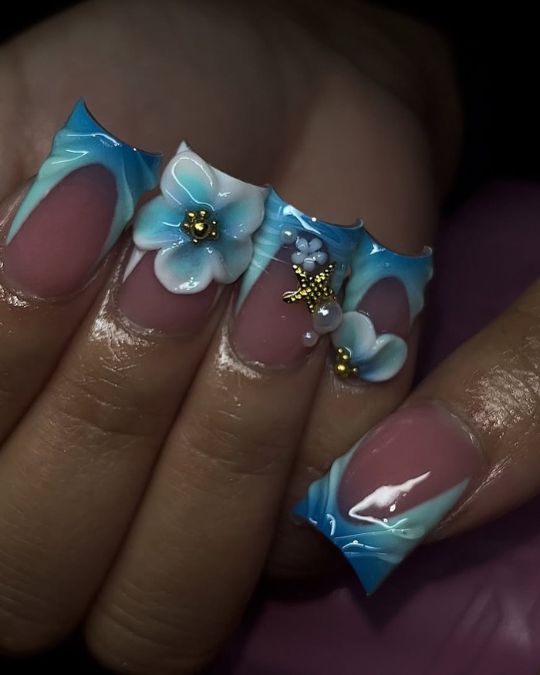 short square nails with blue 3 D flowers and swirls french tip