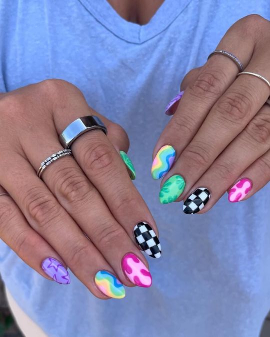 short almond mismatched nails of rainbow swirls, checkerboard patterns, and funky designs