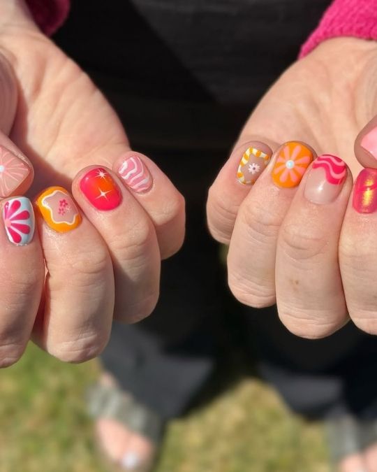 short round nails with Vibrant oranges and pinks with playful retro patterns