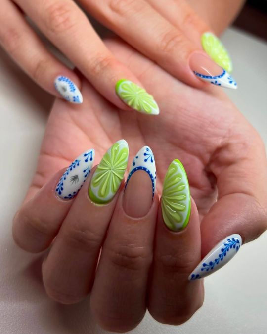 Bright green lemon designs stand out against light blue porcelain-inspired french tip