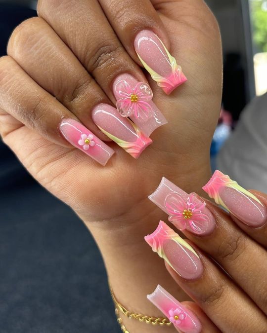 long nails with different shades of pink and transparent 3D flowers