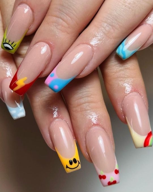 Playful French tips with diverse designs: smiley, cherries, eye, lightning bolt.