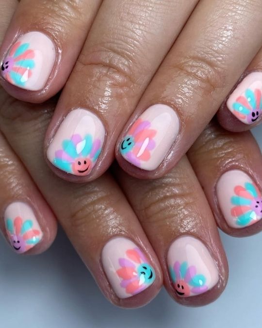 short round nails with pastel flowers with smiling faces
